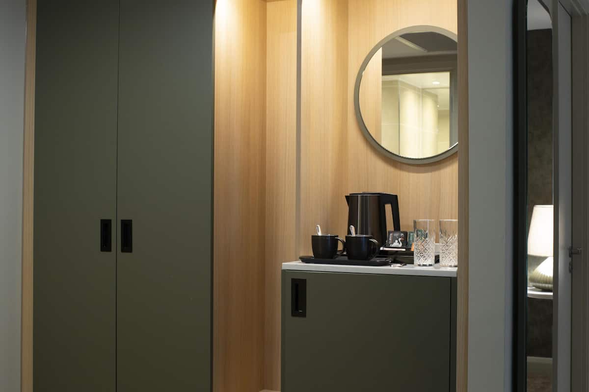 Une salle de bain avec un meuble-lavabo en bois, un miroir et une machine à café.