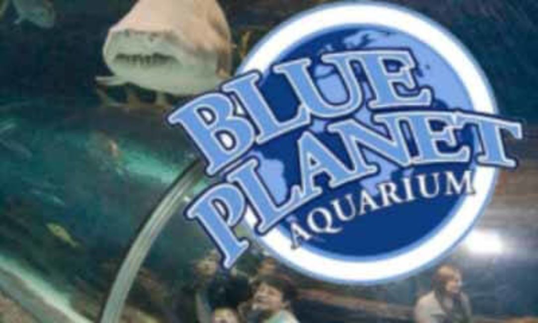 Letrero del Acuario Blue Planet, con un tiburón visible al fondo.