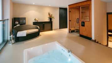 Une salle de bain moderne avec une grande baignoire, un canapé et un meuble en bois.