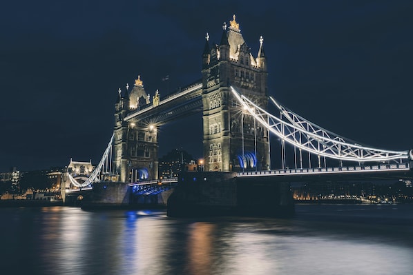 A large, illuminated bridge with two towers and a suspension design.