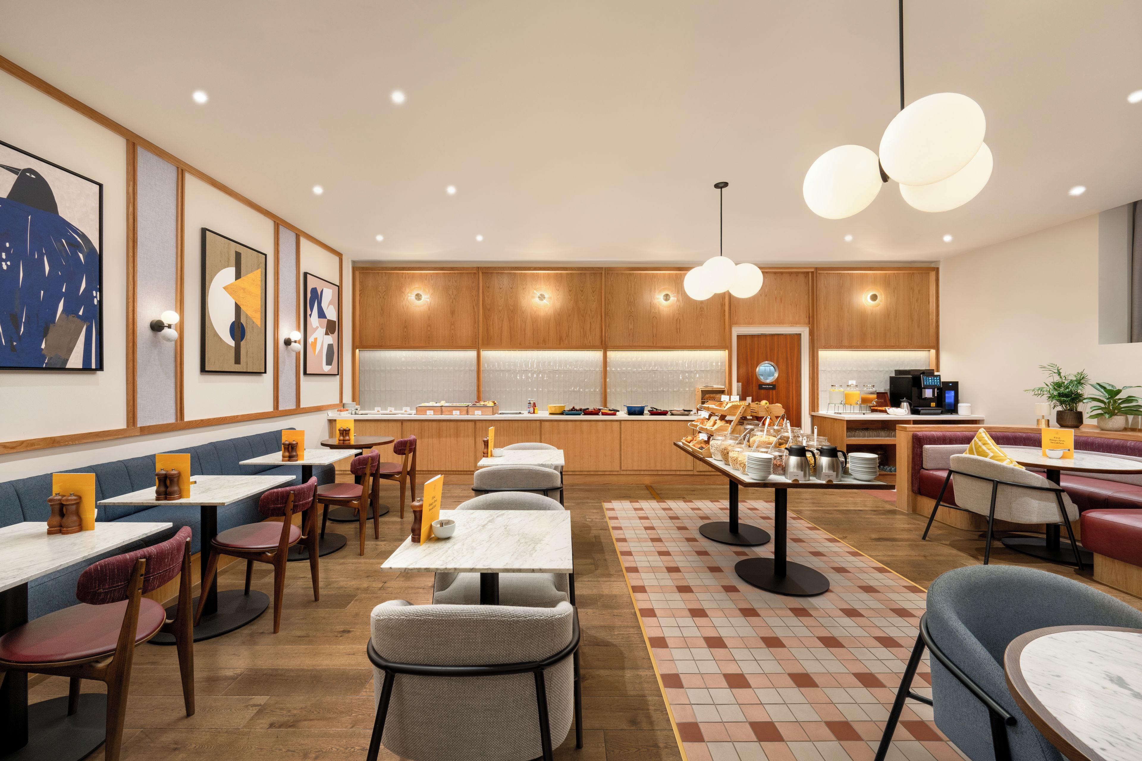 Un restaurante moderno con paneles de madera, mesas de mármol y una zona de bufé central.