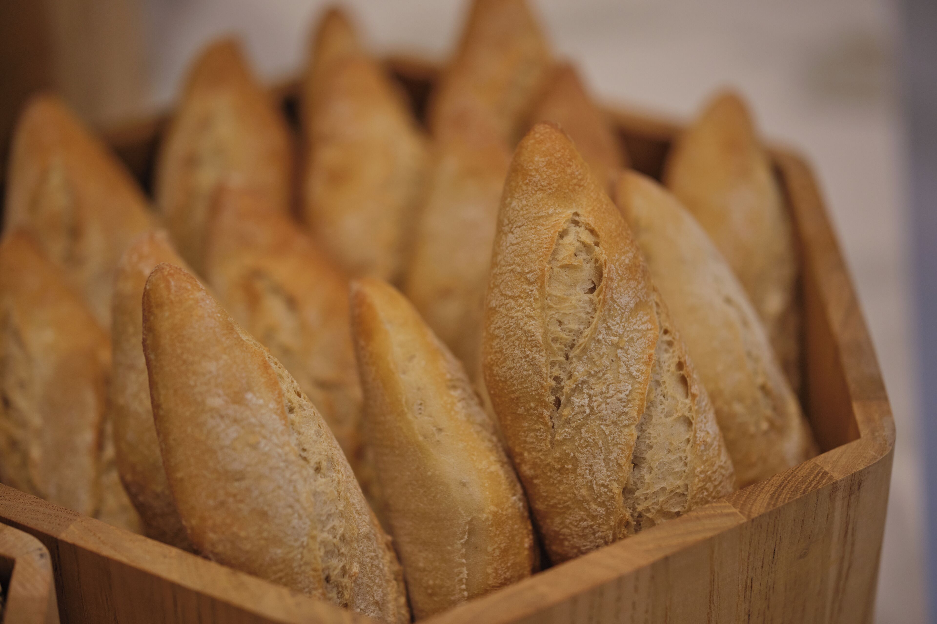 A wooden basket filled with baguettes.