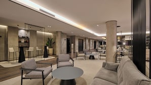 A modern lobby with a seating area, a reception desk, and a staircase. - 1881 Madrid Ventas Hotel (Madrid)