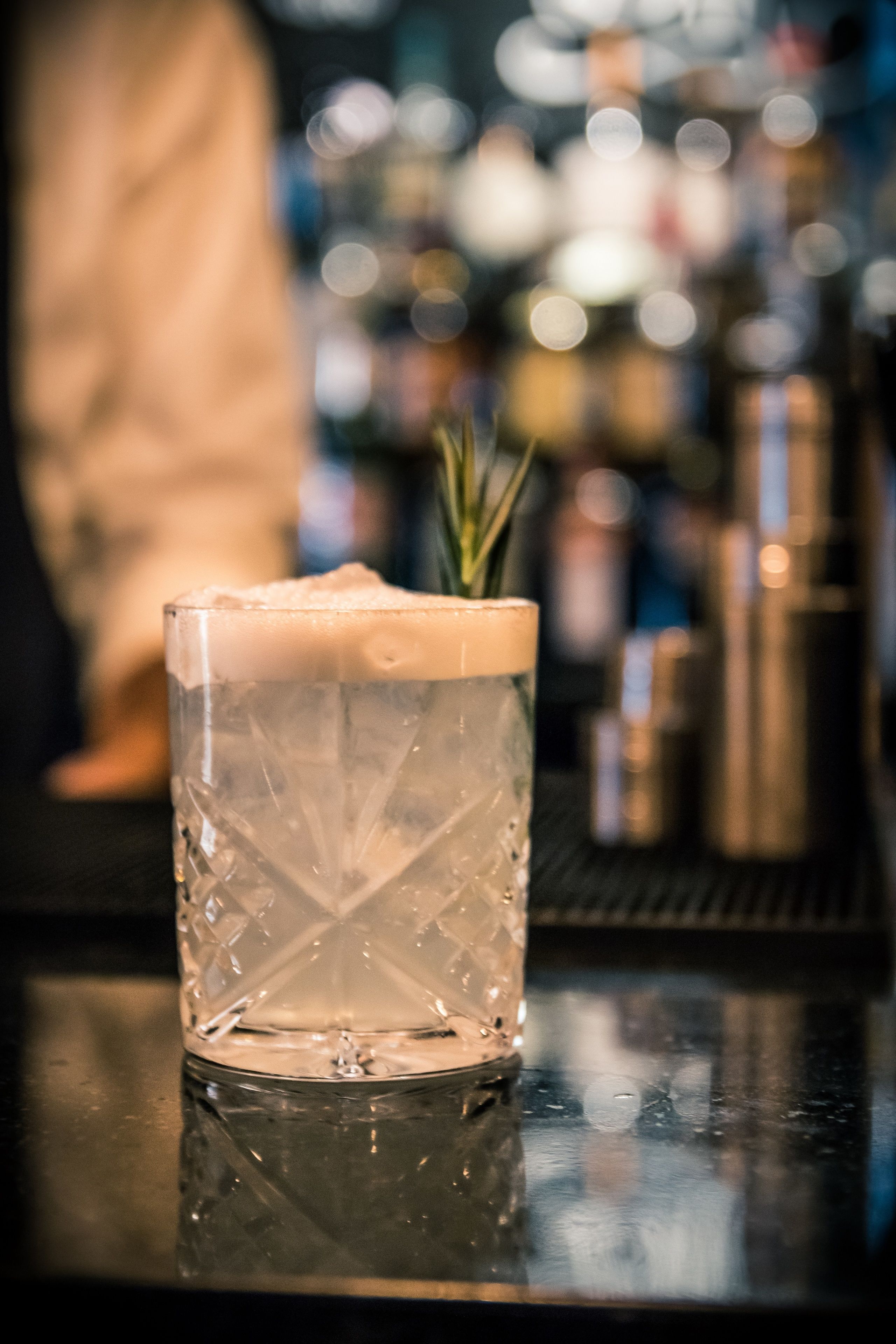A clear glass with a textured pattern, placed on a reflective surface.