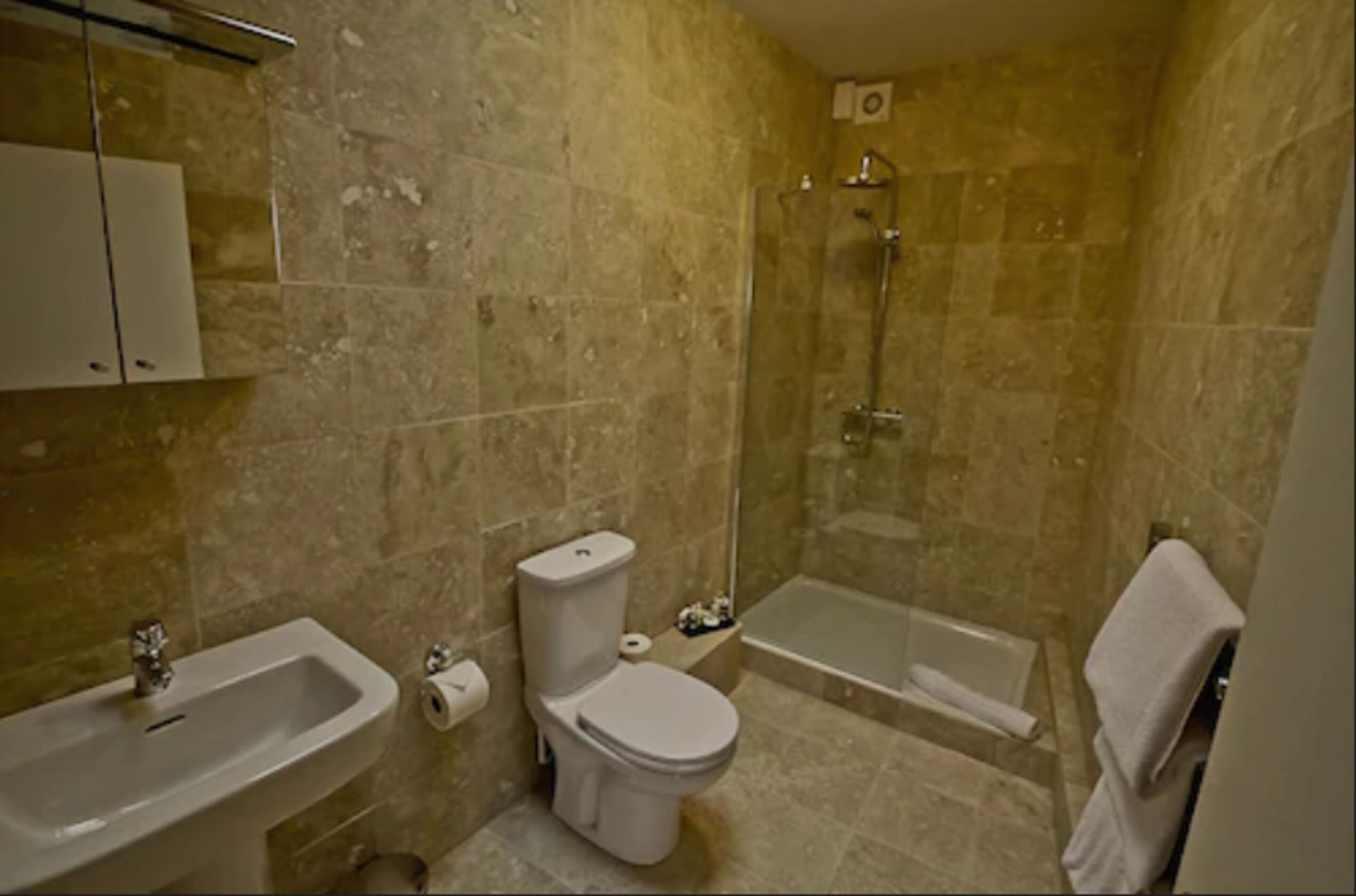 A bathroom with a sink, toilet, and shower.