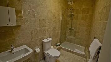 A bathroom with a sink, toilet, and shower.