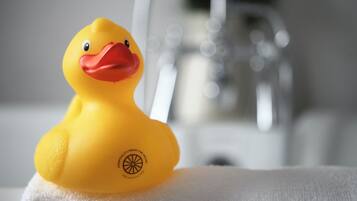 A yellow rubber duck on a white towel.