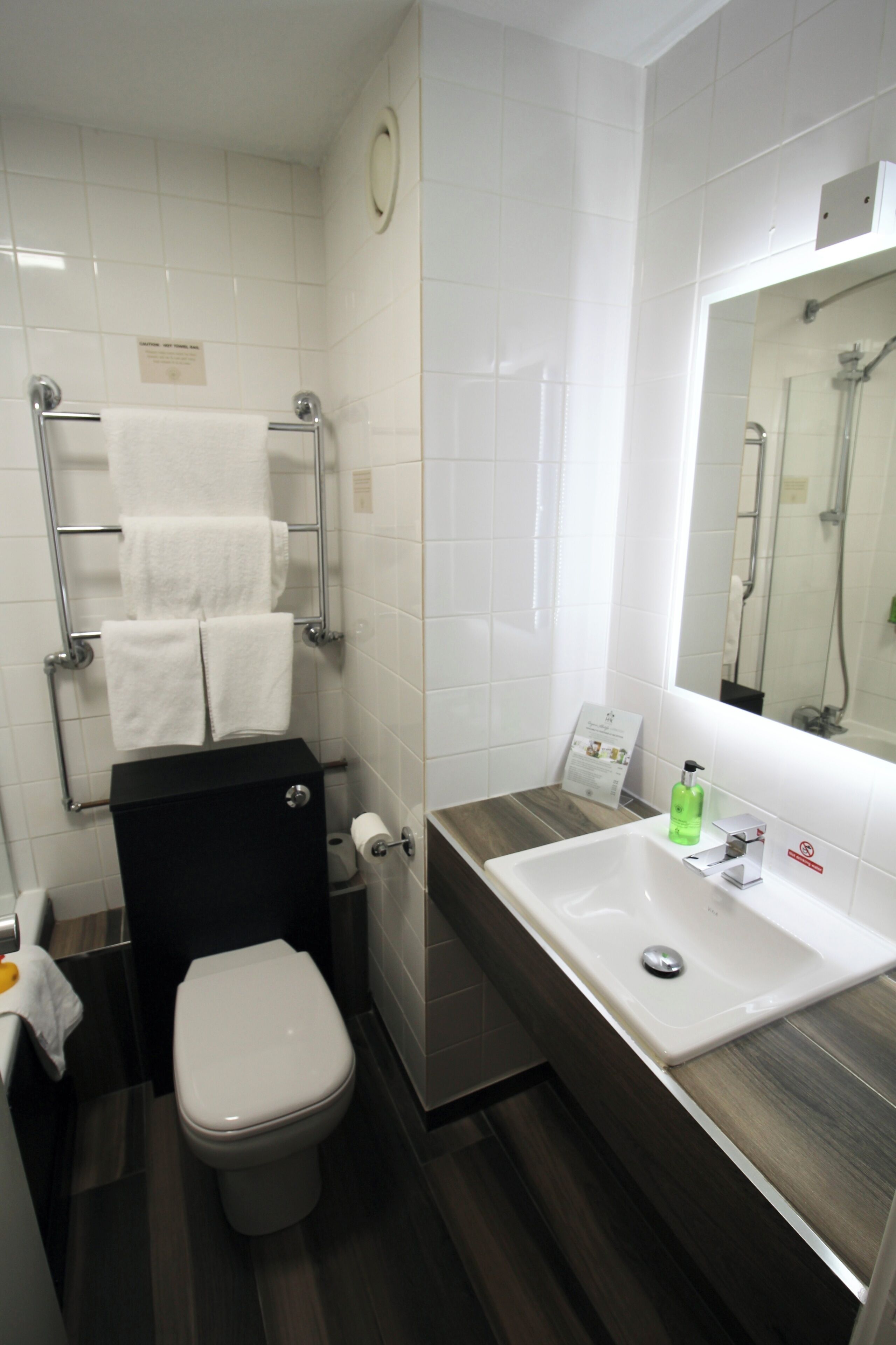 Une salle de bain moderne avec des toilettes, un lavabo et un miroir.