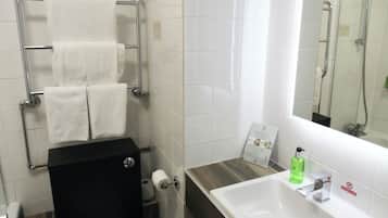 Une salle de bain moderne avec des toilettes, un lavabo et un miroir.