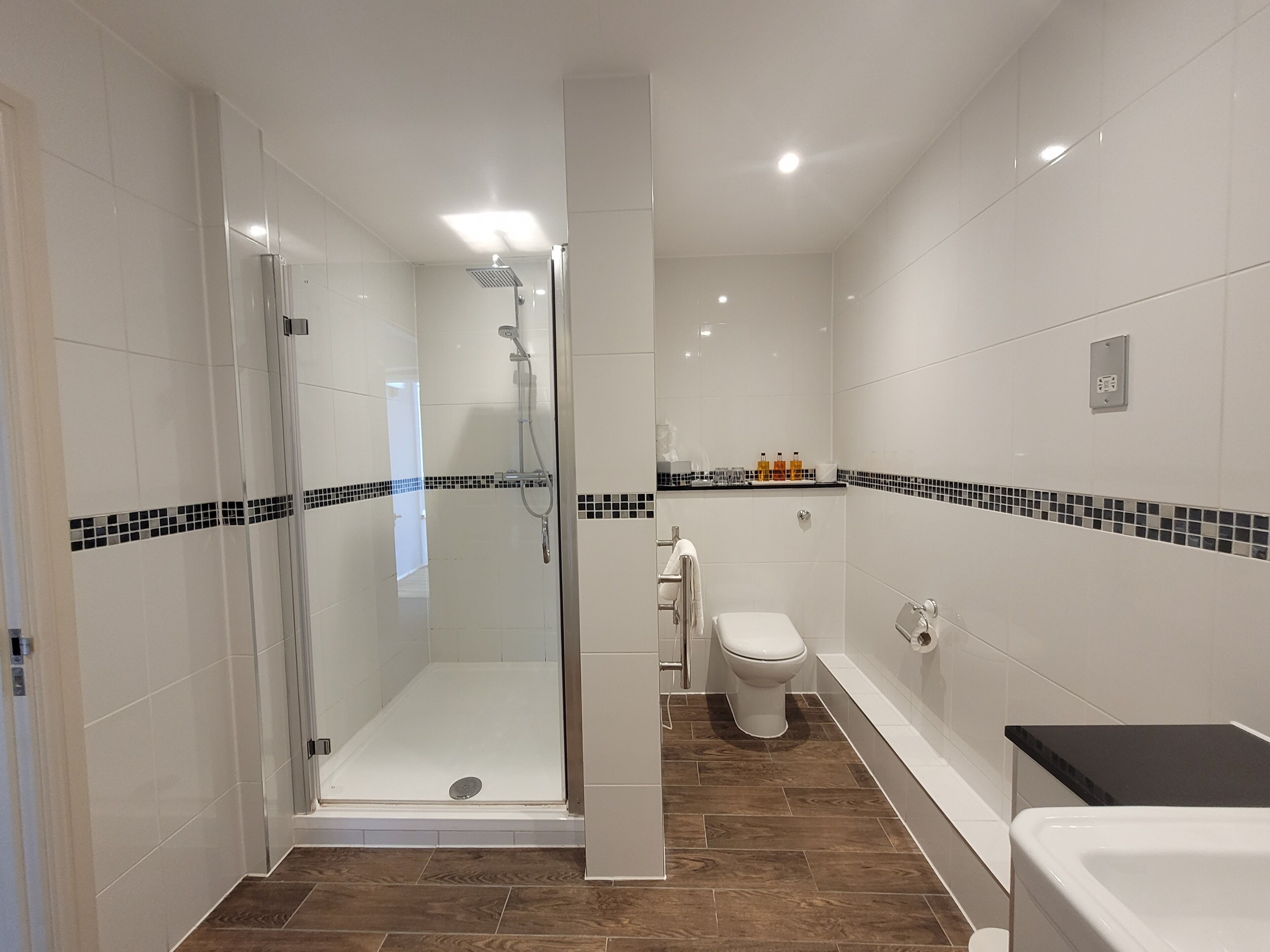 A modern bathroom with a glass-enclosed shower, a toilet, and a bathtub.