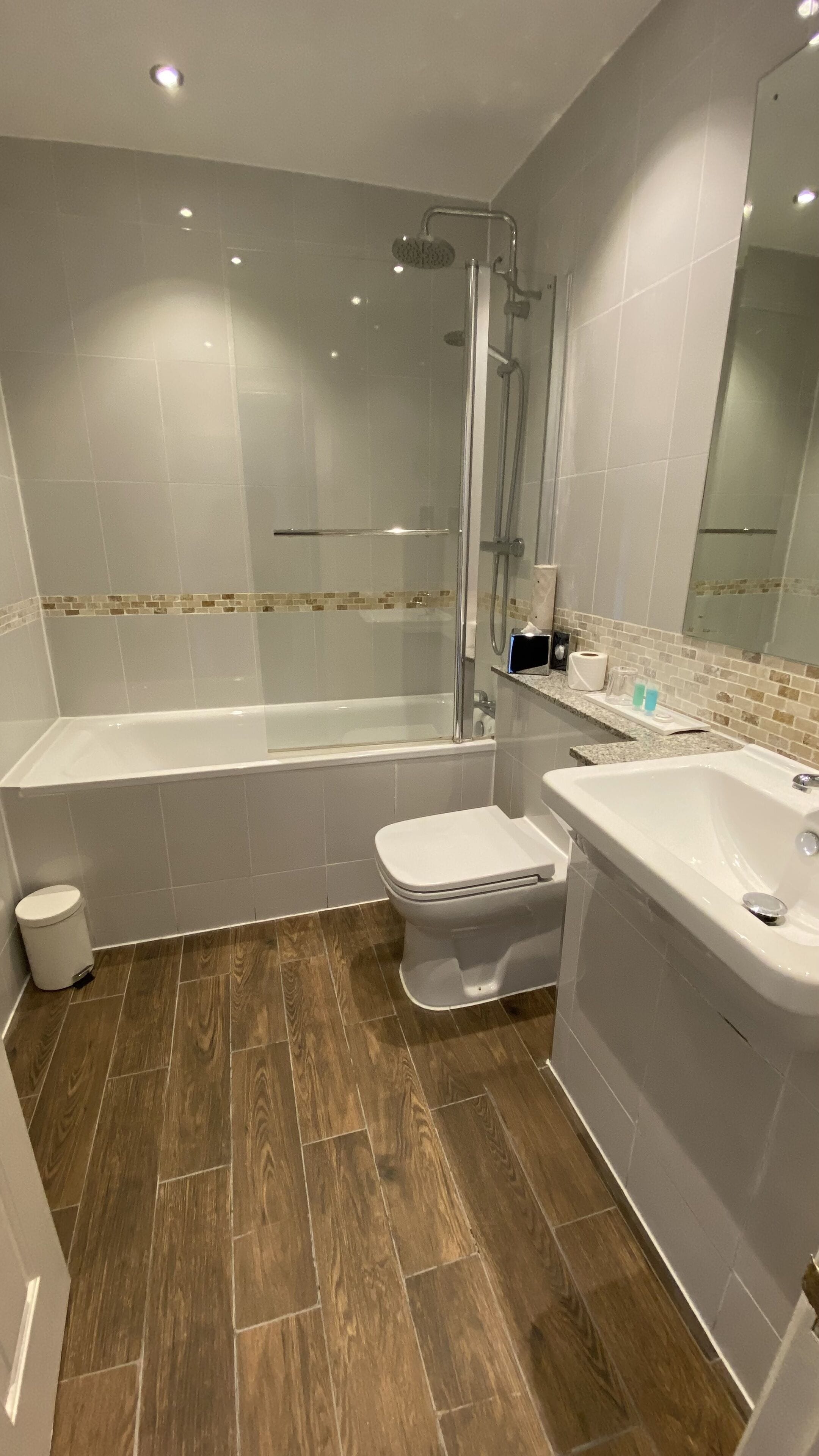 A modern bathroom with a bathtub, toilet, and sink.