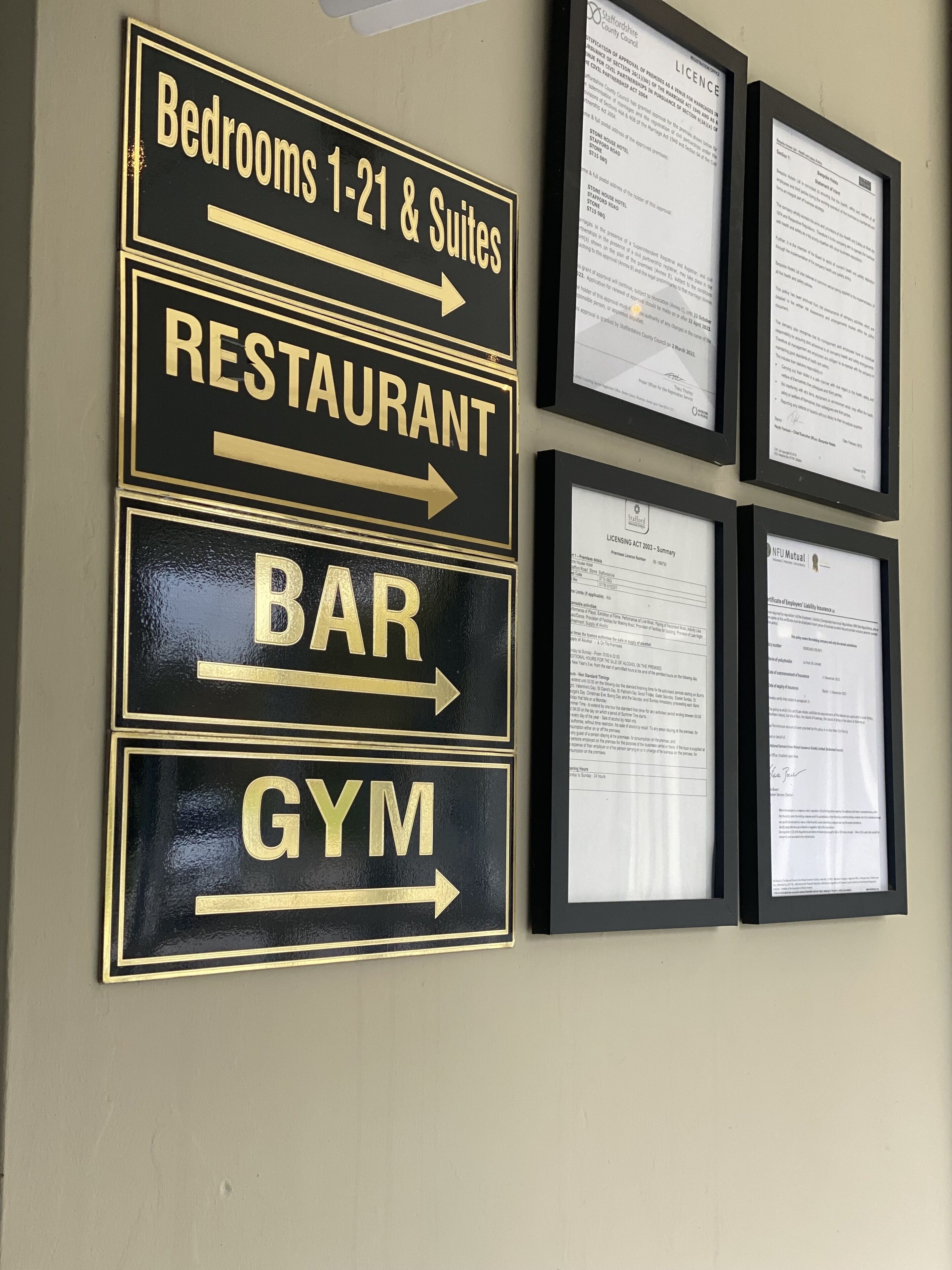 Pared con indicaciones direccionales para 'Bedrooms 1-21 & Suites', 'Restaurante', 'Bar' y 'Gimnasio'.
