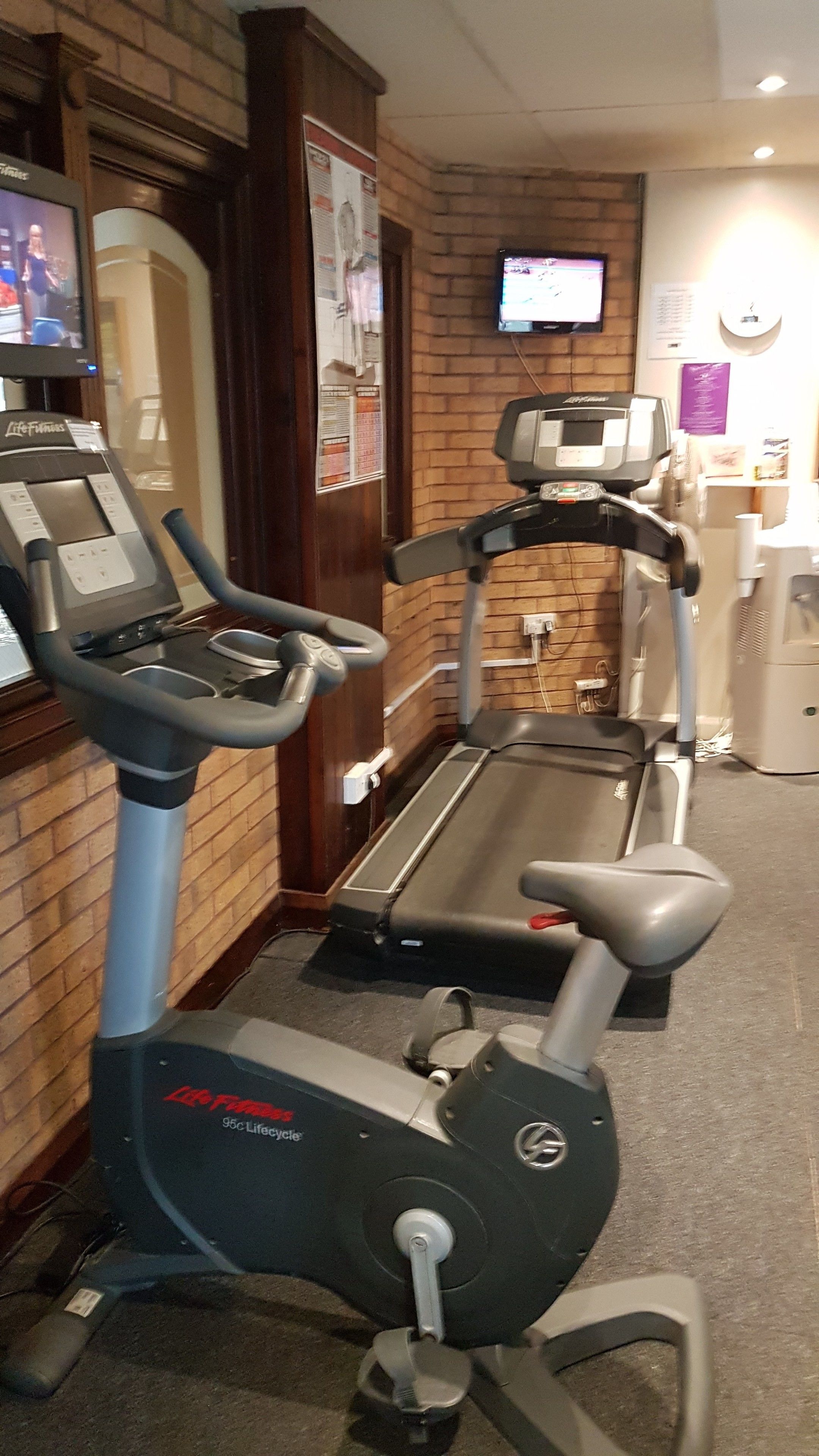 Un gimnasio con cintas de correr y una máquina elíptica.