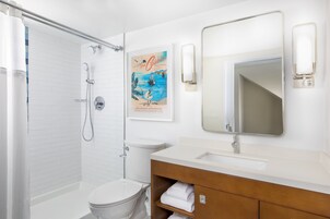 A modern bathroom with a shower, toilet, and vanity.