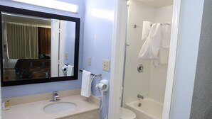A bathroom with a sink, mirror, and a shower area. - Super 8 by Wyndham Florence SC I-95 North / Hwy 76 (Florence)
