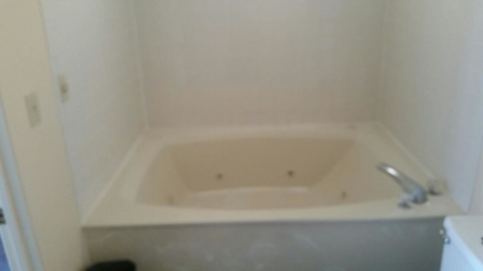 Un baño pequeño y sencillo con bañera, inodoro y lavamanos.
