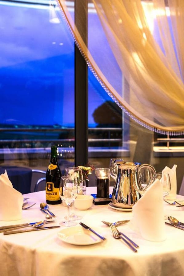 A table set for dining with a bottle of champagne, glasses, and cutlery. - Ballyroe Lodge (Tralee)