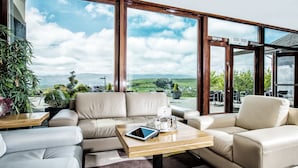 A spacious living area with a large window offering a scenic view of the countryside. - Ballyroe Lodge (Tralee)
