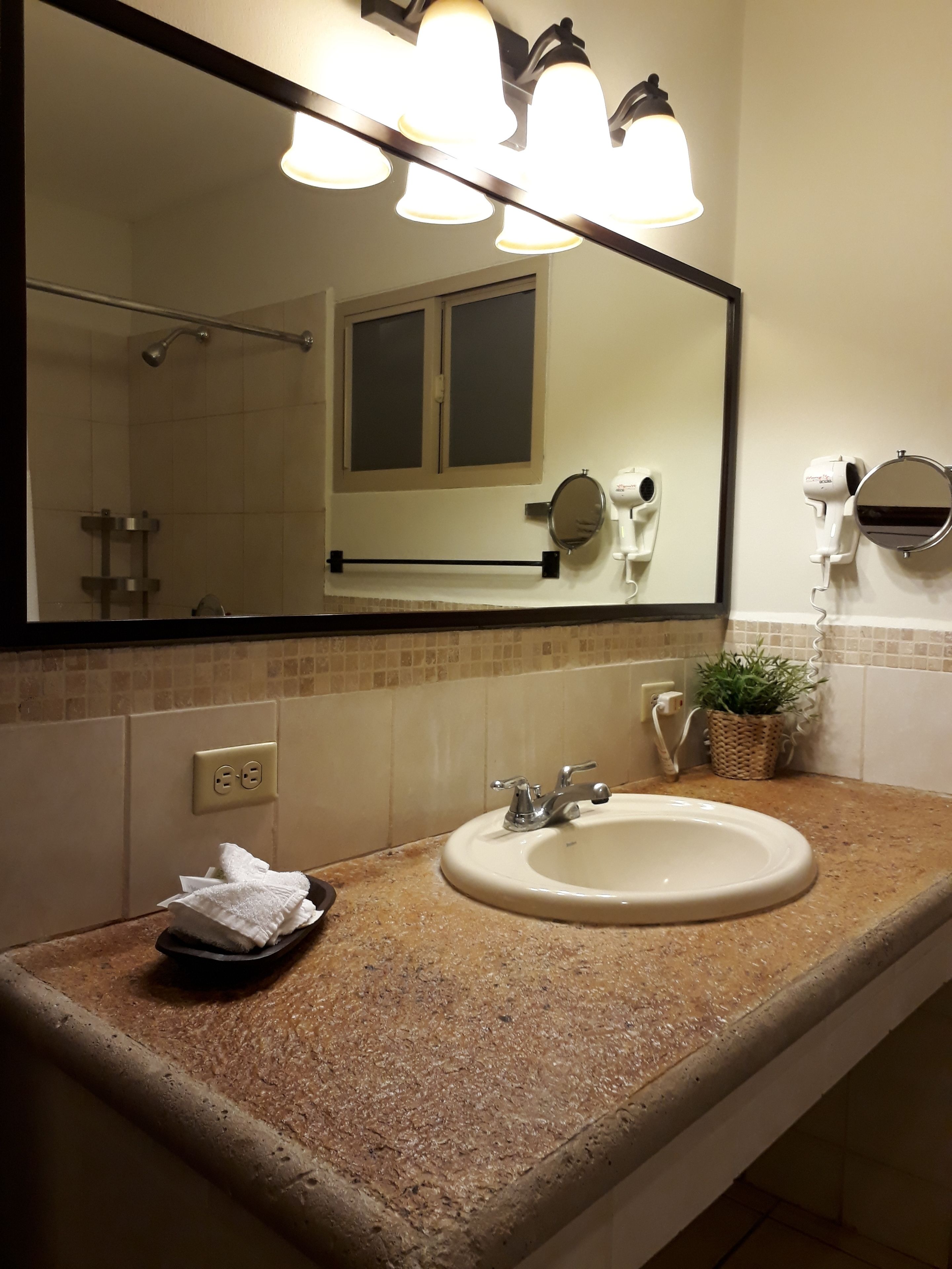 A bathroom with a sink, mirror, towel rack, and a hairdryer.