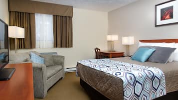 Une chambre d’hôtel avec un lit, un canapé, un bureau et une chaise.