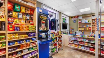 A candy and snack store with shelves stocked with various brands and a cash register.