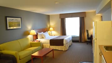 A hotel room with a bed, a yellow sofa, a wooden table, and a desk with a chair.