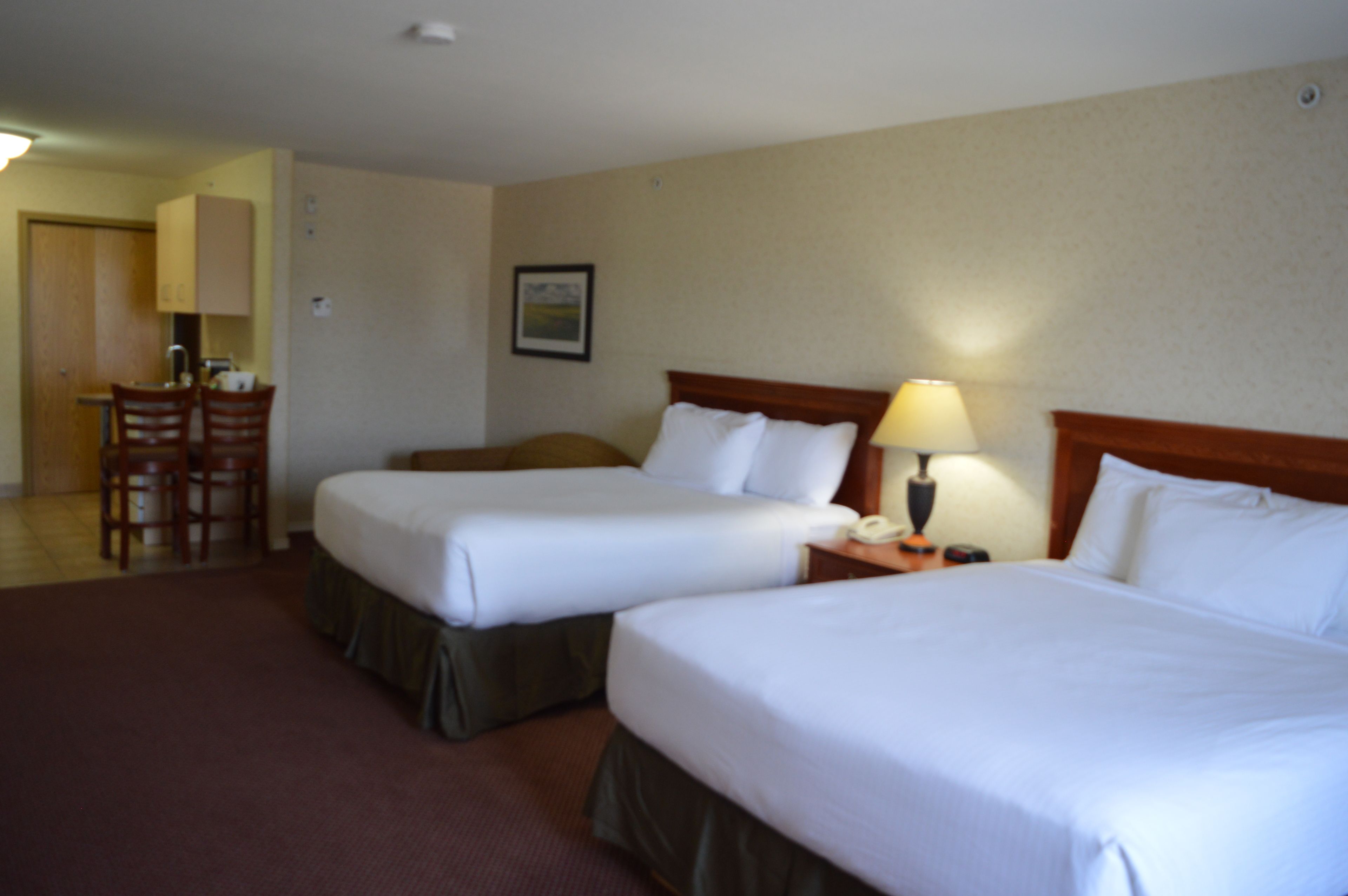 Une chambre d’hôtel avec deux lits, un bureau et une chaise.