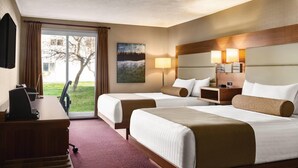 A hotel room with two beds, a desk, a chair, a TV, and a window with curtains. - Atlantic Host Hotel, an Ascend Collection Hotel (Bathurst)