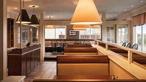 A restaurant with booths, pendant lights, and a counter. - Atlantic Host Hotel, an Ascend Collection Hotel (Bathurst)