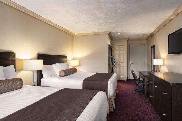 A hotel room with two beds, a desk, a chair, a television, and a door. - Atlantic Host Hotel, an Ascend Collection Hotel (Bathurst)