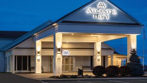 A hotel with a covered entrance, a prominent sign, and a well-lit facade. - Atlantic Host Hotel, an Ascend Collection Hotel (Bathurst)