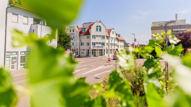 A street view with a building featuring a red roof and multiple windows. - PLAZA INN Blankenburg Ditzingen, Sure Hotel Collection (Ditzingen)