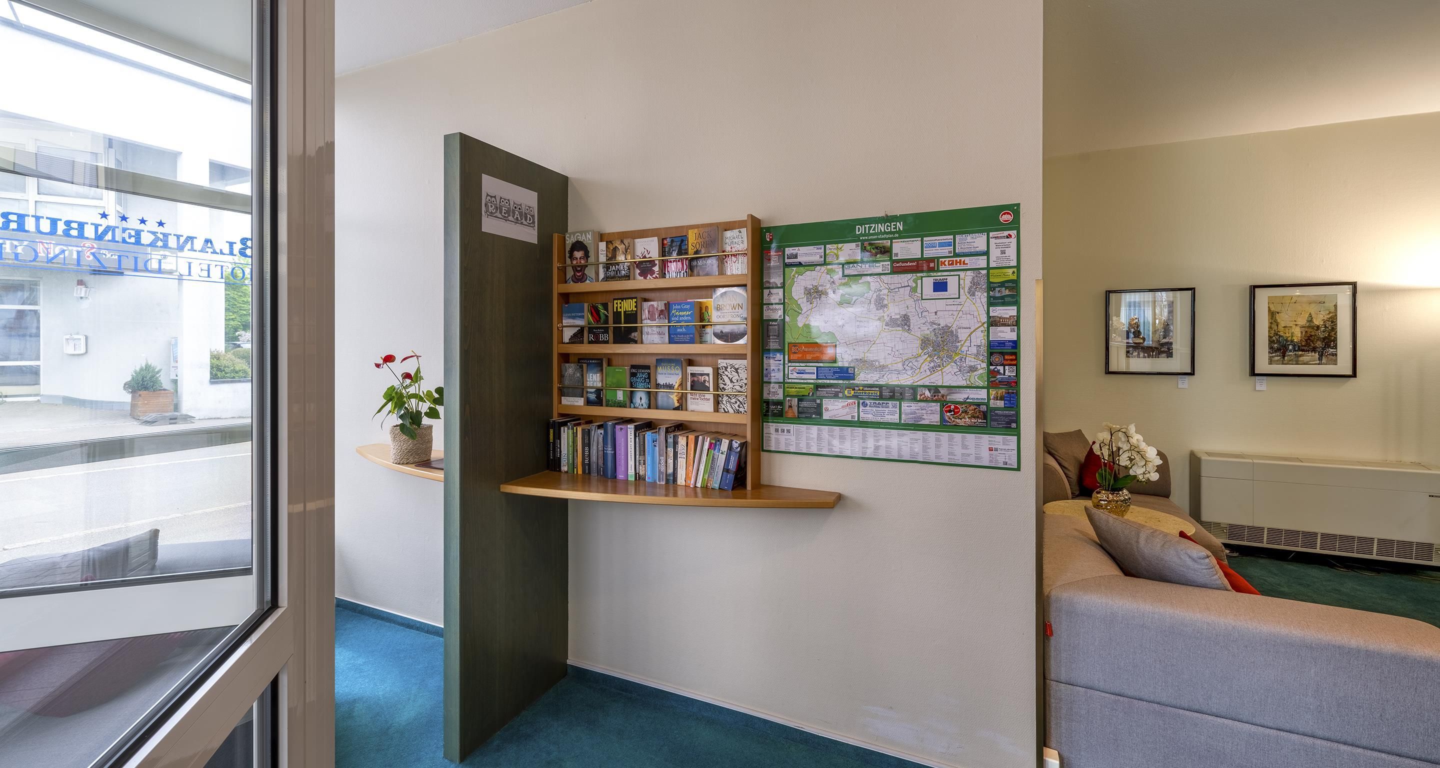 Une bibliothèque avec des étagères, une carte et un canapé.