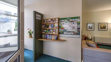 Une bibliothèque avec des étagères, une carte et un canapé.