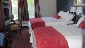 Een hotelkamer met twee bedden, een televisie, een bureau en een stoel.