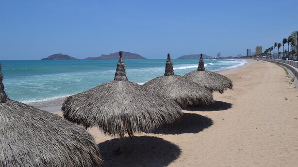 A beach with thatched umbrellas and a clear view of the ocean. - Hotel Sands Arenas (Mazatlán)