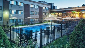 A modern hotel with a swimming pool, outdoor seating, and a restaurant area. - HFX Airport Hotel (Goffs)