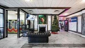 A lobby with a fireplace, a Christmas tree, and a seating area. - HFX Airport Hotel (Goffs)