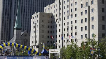 A large crowd in front of a historic building with a green roof and multiple flags.