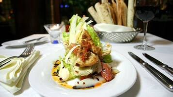 A plate of food with a glass of wine on a table.