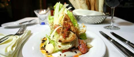A plate of food with a glass of wine on a table.