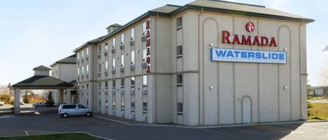Een meerhoog gebouw met een bord waarop 'RAMADA WATERSLIDE' staat.