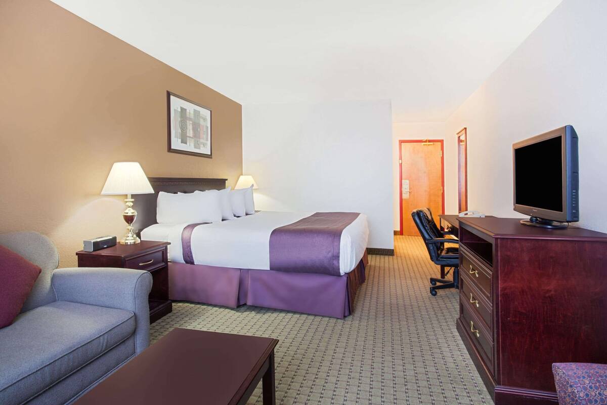 Une chambre d’hôtel équipée d’un lit, d’un bureau, d’une télévision et d’une chaise.