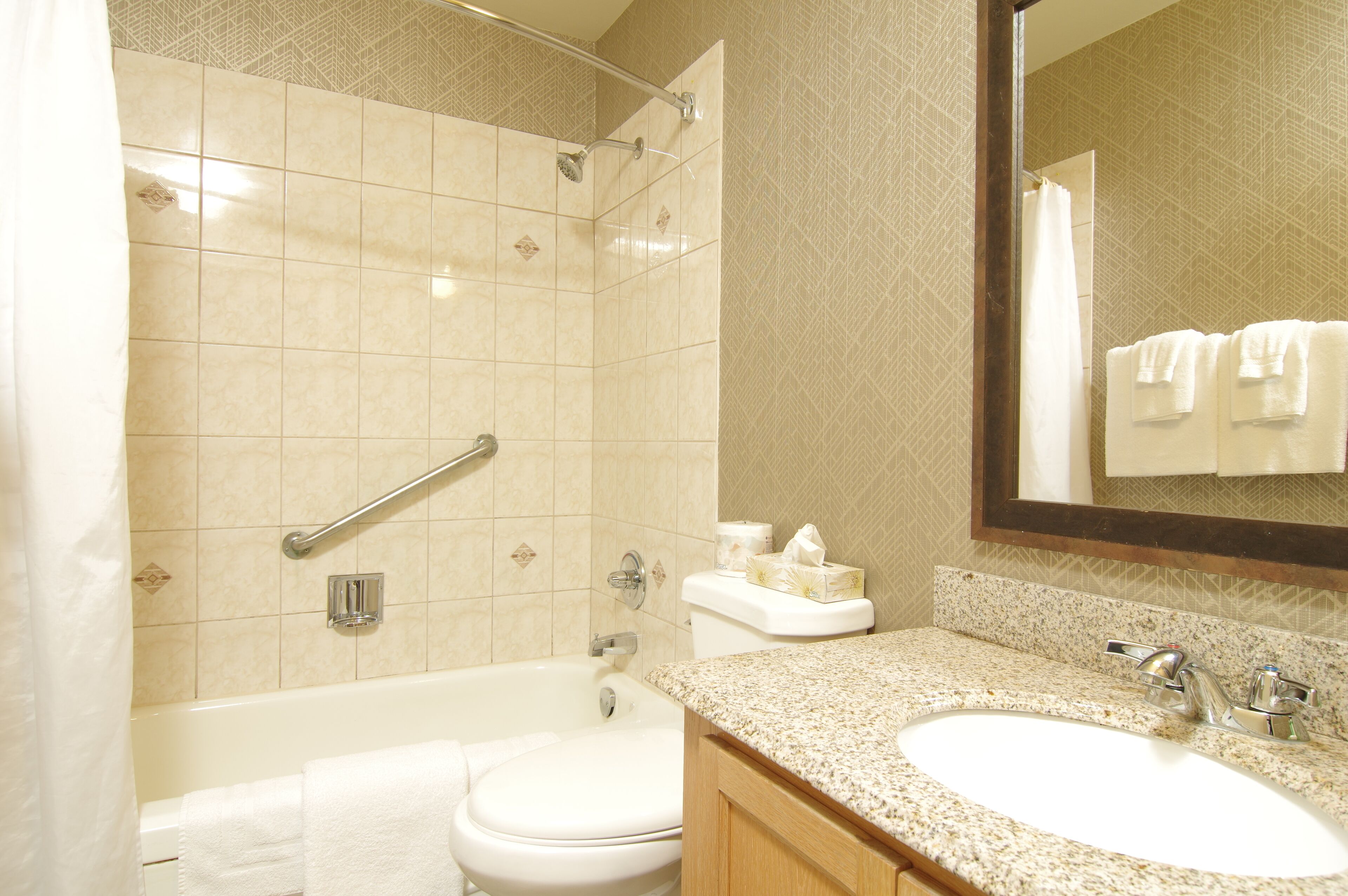 A bathroom with a bathtub, toilet, and sink.