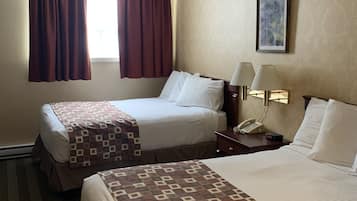 A hotel room with two beds, a nightstand with a lamp, a telephone, and a painting on the wall.