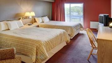 Une chambre d’hôtel avec deux lits, un bureau, une chaise et un téléviseur.