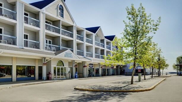 A multi-story hotel with balconies, a covered entrance, and a view of the street.
