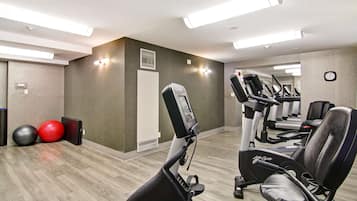 Et fitnessrum med træningsudstyr, et spejl og træningsbolde.