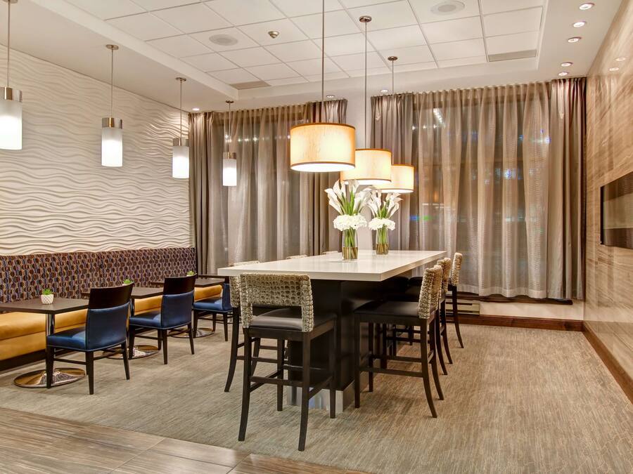 Un comedor moderno con una mesa rectangular, varias sillas e iluminación colgante.