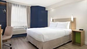 A hotel room with a bed, a desk, a chair, and a window with curtains. - Spark by Hilton Toronto Airport (Toronto)
